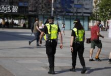 Etaty w straży miejskiej czekają. Katowicka jednostka oferuje m.in. 4430 zł brutto i 13-stkę na zdjęciu widać z tyłu parę strażników miejskich spacerujących po katowickim Rynku