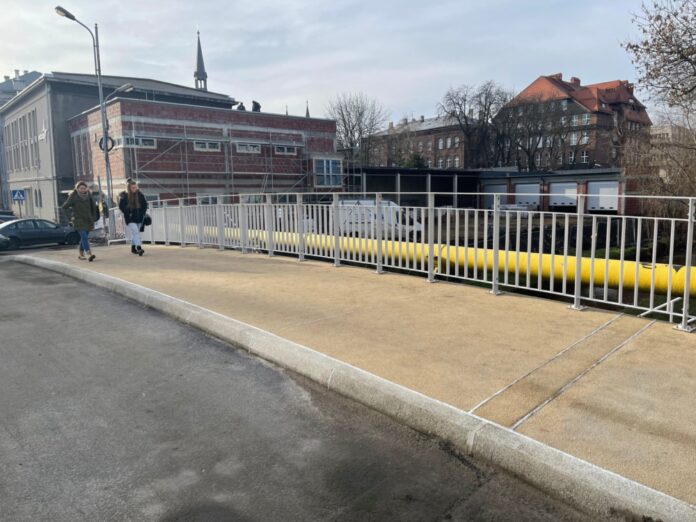 MZUiM bierze się za remonty kładek i mostów_01 Na zdjęciu widać dwie osoby, które wchodzą na nowo wyremontowany most nad Rawą na ulicy Bankowej
