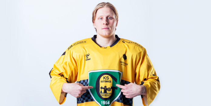 na zdjęciu nowy fińskim obrońca klubu pozuje do kamery ubrany w żółtą hokejową koszulkę GieKSy