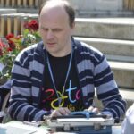 W Katowicach można wypożyczyć książki w „wersji audio” – rozmawiamy z Czesławem Chmielem z Katowickiej biblioteki Na zdjęciu Czesław Chmiel piszący na maszynie brajlowskiej