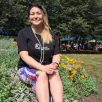 Murale, place zabaw czy strefy sportowe. Małgosia z Katowic zmienia dzielnice na lepsze dzięki Budżetowi Obywatelskiemu uśmiechnięta Magłorzata Norek siedzi w krótkiej spódniczce i czarnej krótkiej koszulce