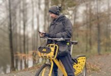 Mieszkam w Katowicach, ale to nie moje miasto Łukasz Folda stoi przy rowerze i przegląda telefon komórkowy