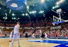 KoszKadra zagra w Spodku ze Szwecją w ramach przygotowań do EuroBasketu 2025 z przodu koszykarz w białym stroju, w tle wypełnione kibicami trybuny Spodka
