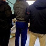 Kradł kawę i alkohol w Katowicach. 38-latek z 28 zarzutami i sprawą o narkotyki Zatrzymany mężczyzna prowadzony przez dwóch policjantów