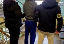 Kradł kawę i alkohol w Katowicach. 38-latek z 28 zarzutami i sprawą o narkotyki Zatrzymany mężczyzna prowadzony przez dwóch policjantów