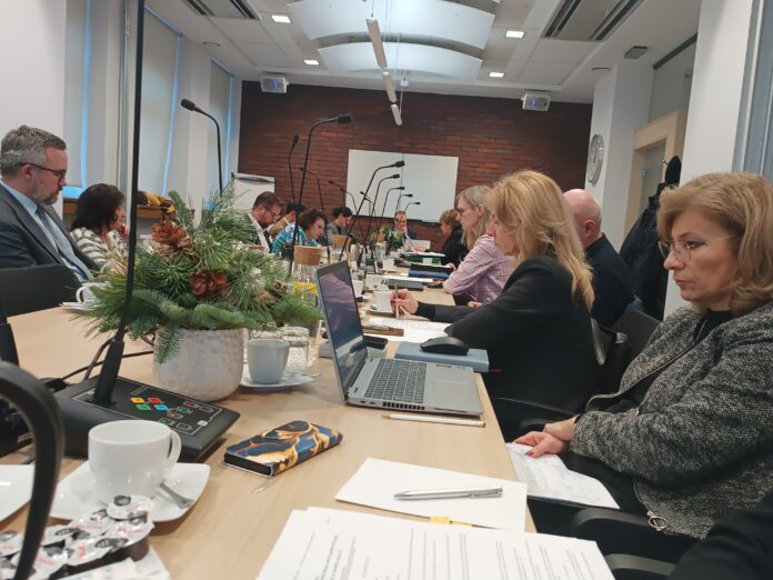 Ludzie siedzący przy mikrofonach